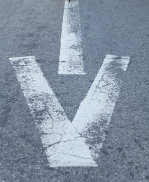Caucasian woman riding bicycle over arrow on road